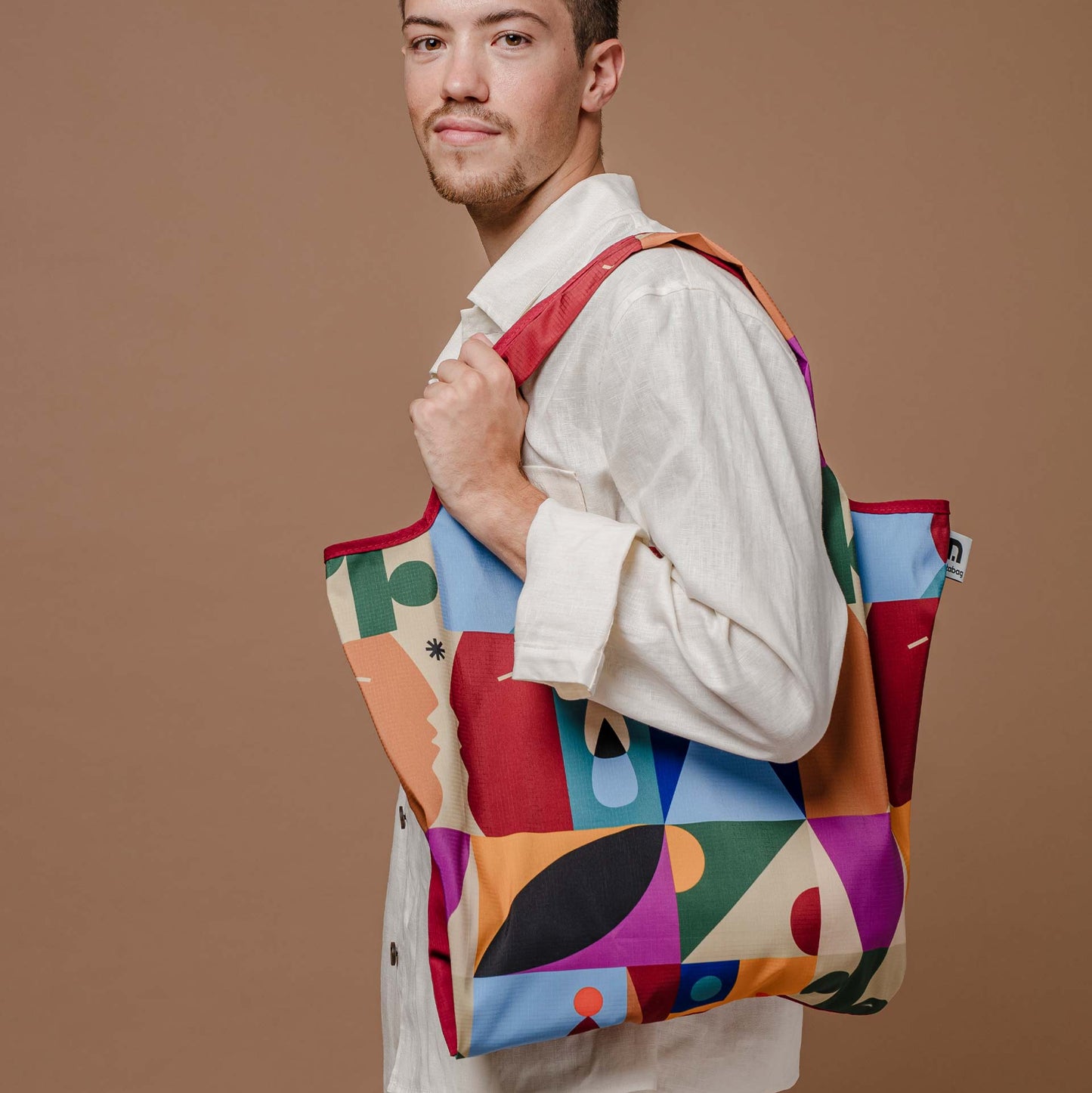 A sturdy, foldable, lightweight and spacious shopping tote - colourful design "roots" by Barcelona artist Judit Canela for notabag.